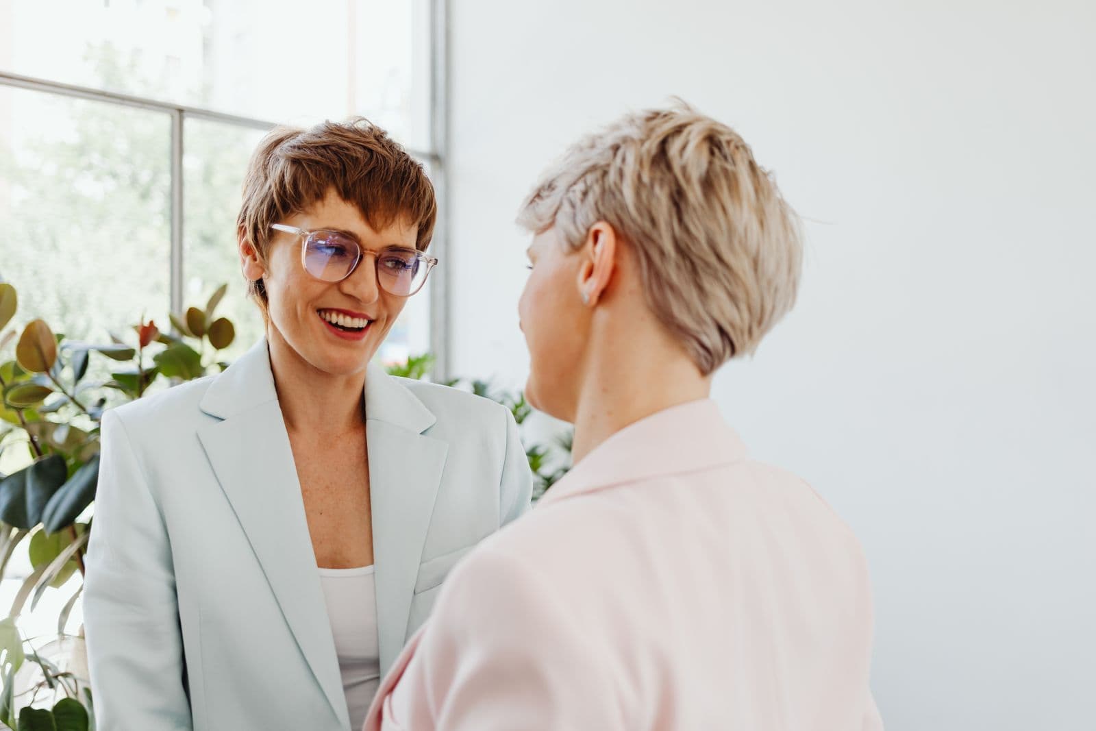 A manager smiles as she talks one to one with a member of her team