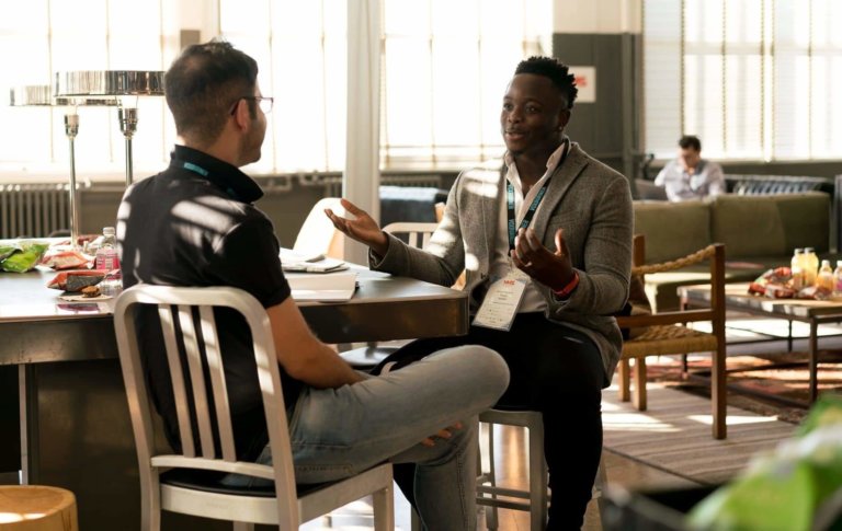 men having conversation at table in networking event