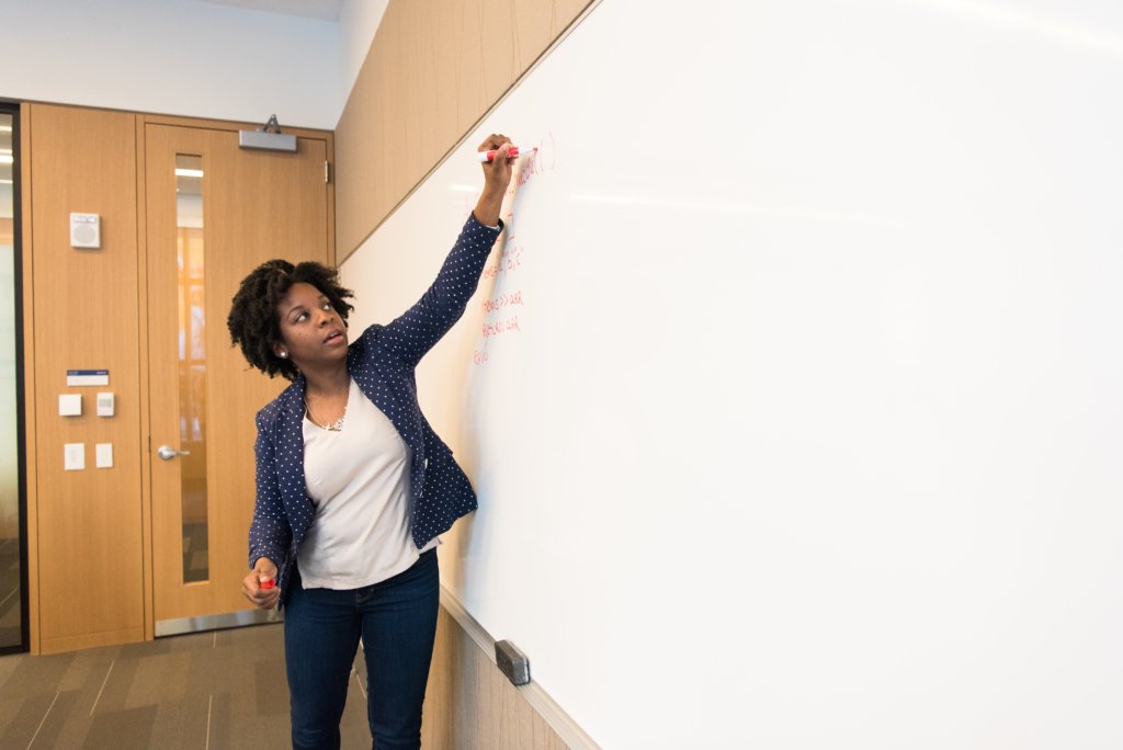 black woman employee writing on whiteboard measuring KPIs