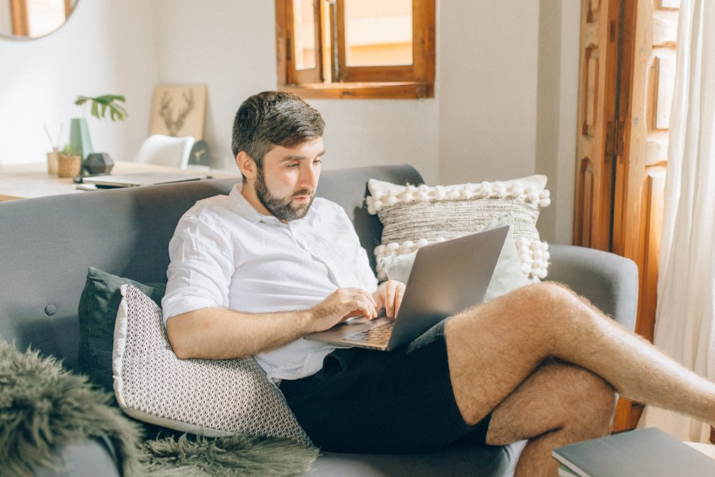 man at home on the couch researching benefits of mentoring in the workplace