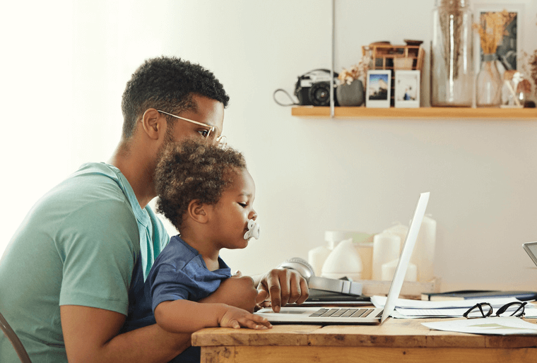 Dad working remotely with baby at home