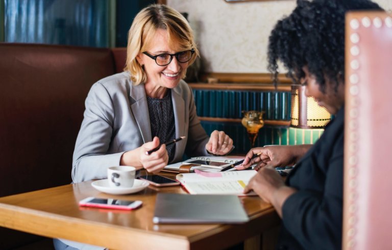 two women meeting in a booth happy workers