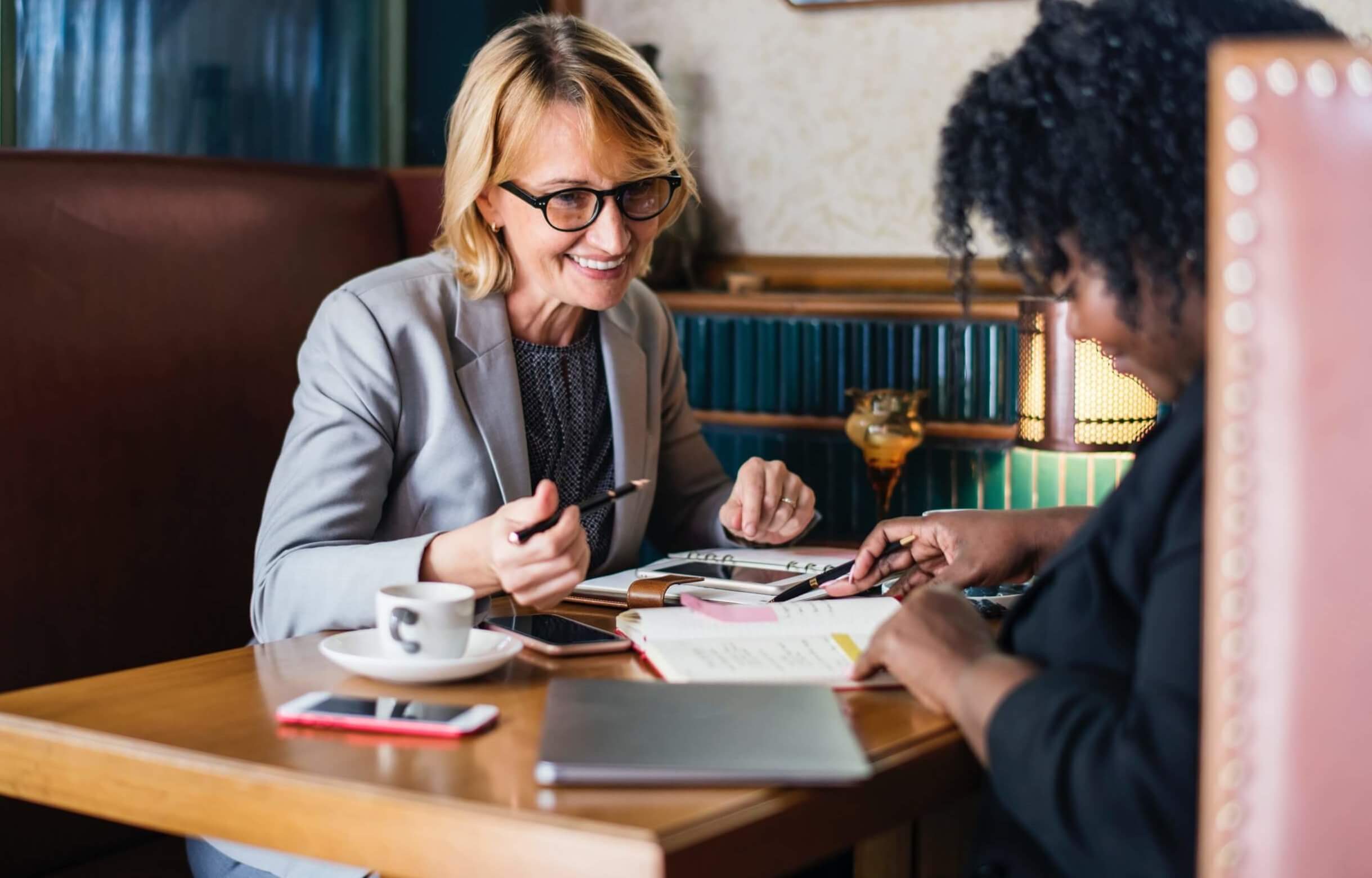 two women meeting in a booth happy workers