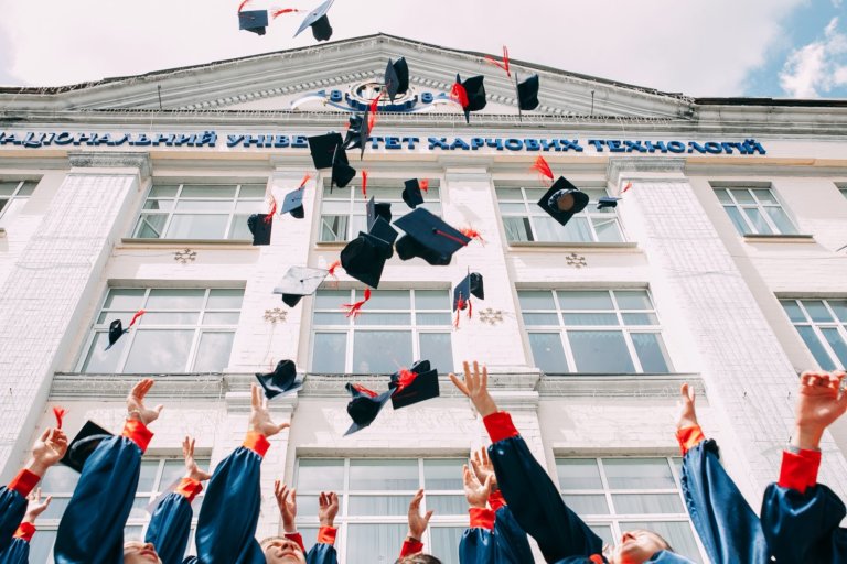 students throwing caps at graduation college