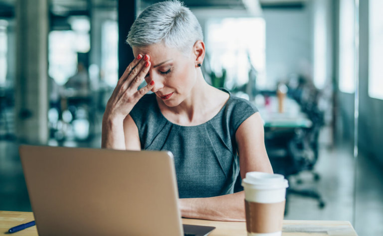stressed businesswoman with headache in the office