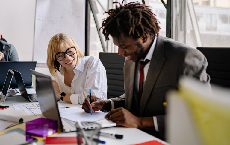 man demonstrating to female coworker in reverse mentoring session at the office