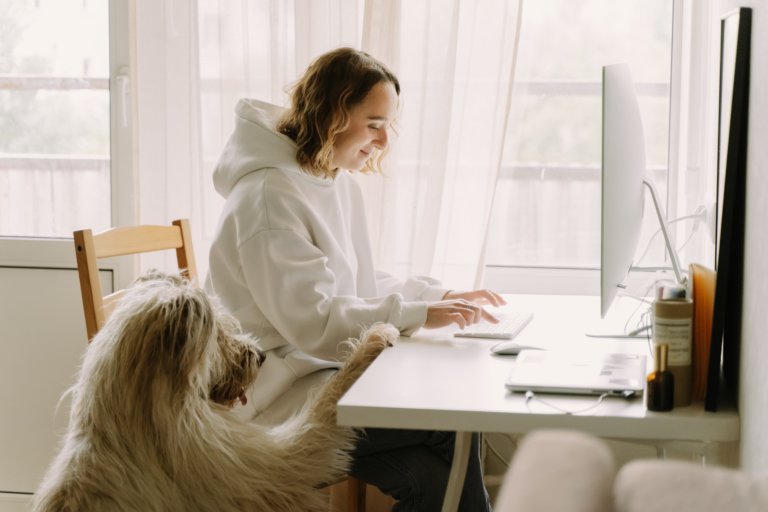 workplace trend: employee flexibility, woman working from home with her dog