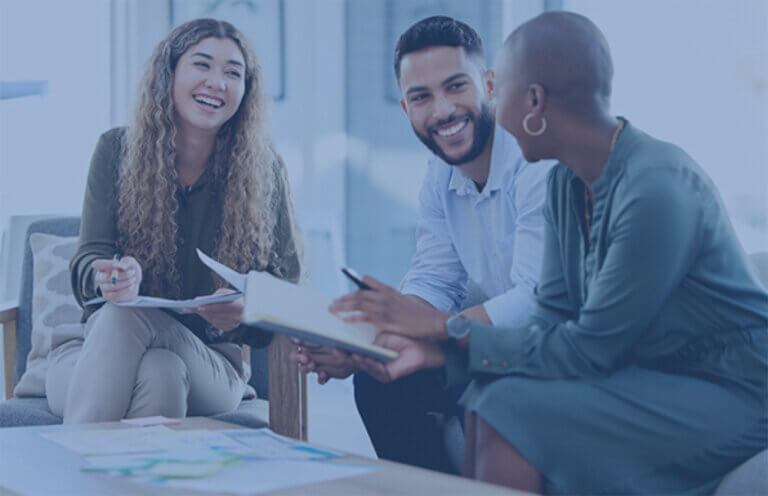 three employees sitting in an ERG meeting discussing the promotion toolkit