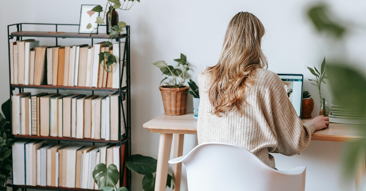 woman employee sitting at her desk alone working on her latop