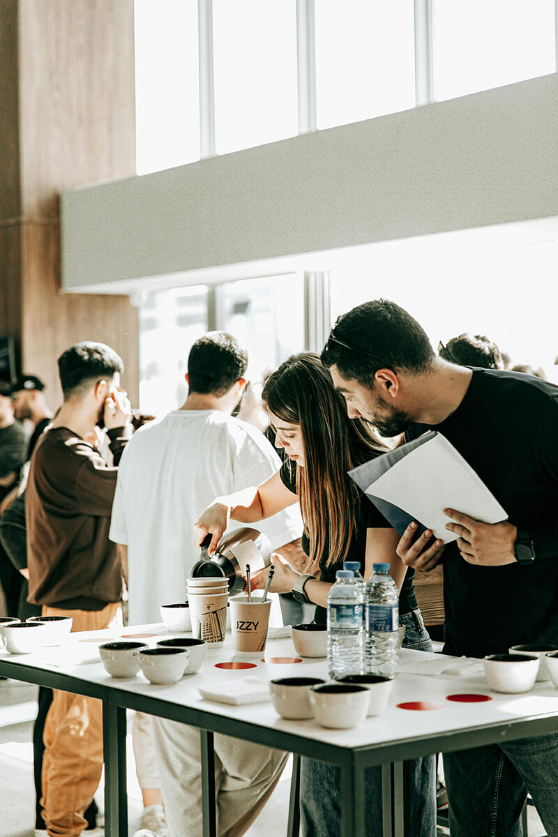 woman pouring coffee, man waiting in line for next cup of coffee at ERG meeting