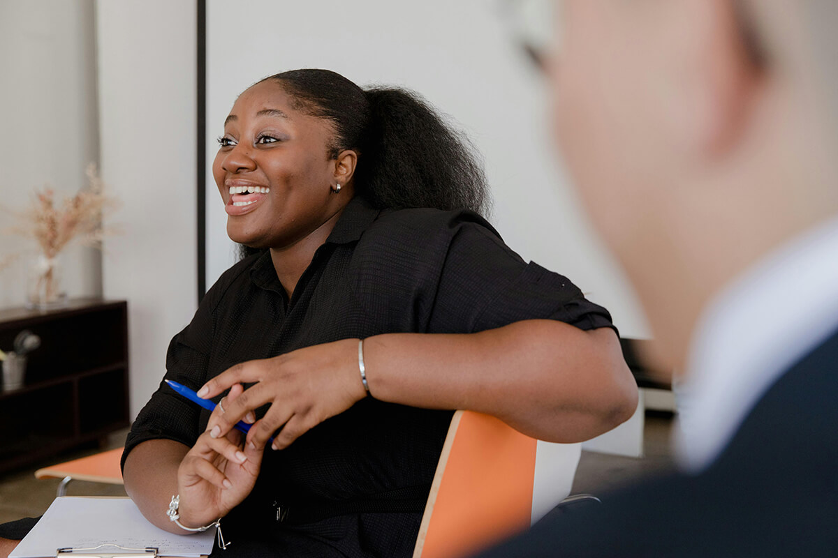 black woman employee talking in BRG meeting, holding a pen