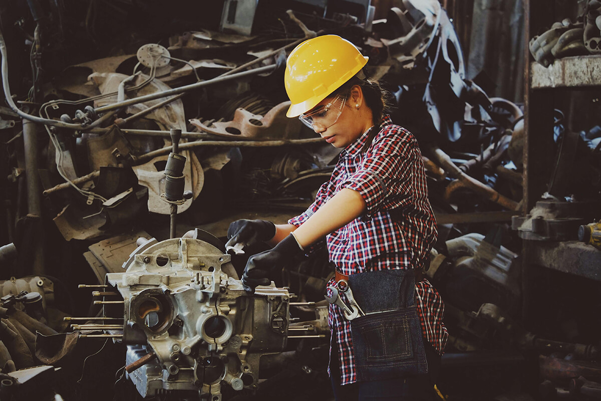 woman in a hard hat working on machinery motivate by her work