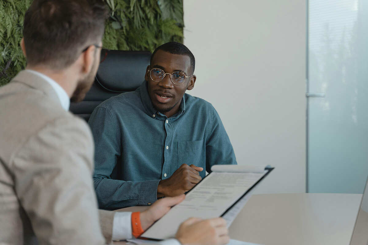 Man sitting in a conference room with colleague while they look at upskilling employees