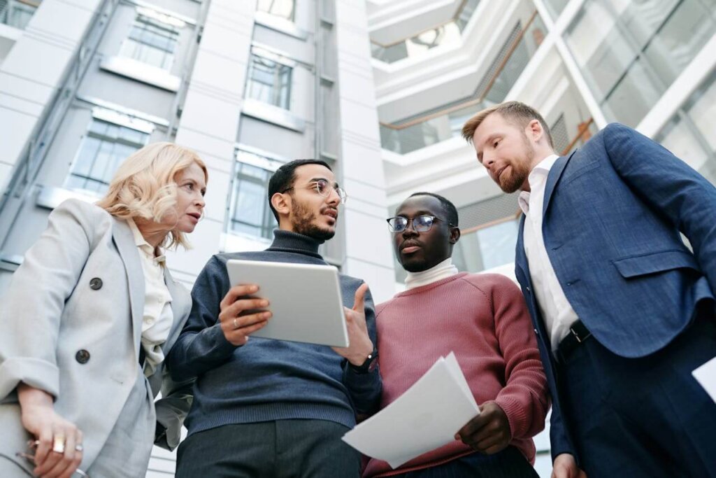 A diverse group of professionals meets in front of an office building.