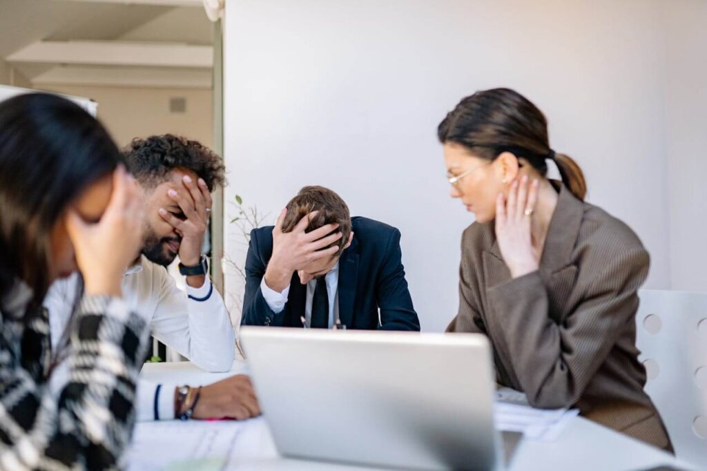 A stressed group of professionals sitting around a conference table.